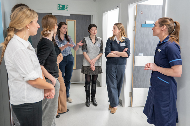A photo of clinical team members showing the esteemed visitors around the NIHR Leeds Clinical Research Facility at St James Hospital.